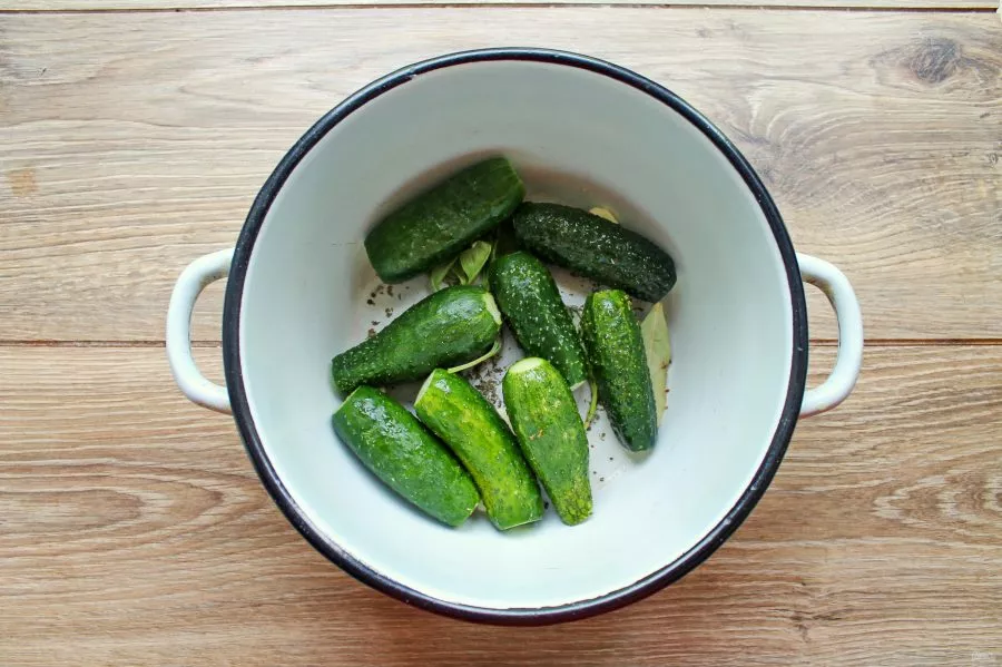 Cut off the ends of the cucumbers and put them in a pot with basil, garlic and a bay leaf.