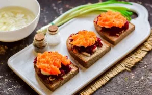 The next layer is grated carrots. Lay out the carrots on top of the beets.