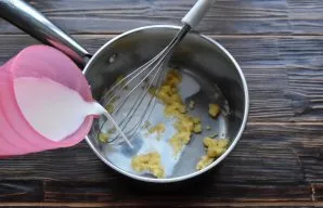 Pour the milk little by little, constantly stirring the sauce with a whisk so as not to form lumps.