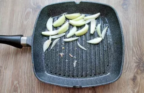 Peel the onions and cut them into slices. Place it in half of the pan in a single layer.