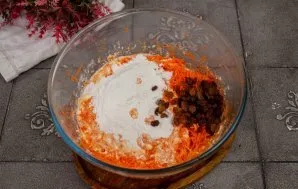 Rinse and dry the raisins, add to the dough. Add the sifted flour. Stir the dough.