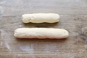 On a table sprinkled with flour, roll the dough into sausages.