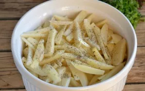 Place the potato strips in layers on the bottom of a heat-resistant baking dish, add salt and pepper to each layer.