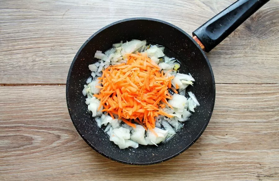 Heat vegetable oil in a frying pan over medium heat and add finely chopped onions and grated carrots. Stir fry everything for 7 minutes.