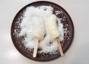 Allow the chocolate to drip a little and roll the bananas in the coconut.