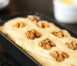 Put the finished dough in a non-stick form, smeared with butter or vegetable oil. Put nuts on top. We bake in an oven preheated to 180 de...