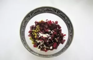 Peel the garlic, chop it, and also add it to the salad.