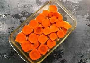 Wash the carrots well under running water, cut into slices and put on top of the chicken fillet.