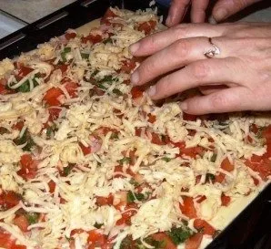 Sprinkle the pizza with a layer of grated cheese. Sprinkle with herbs if desired.