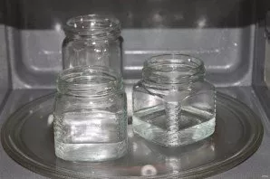 While the mushrooms are boiling, wash the jars with soda with hot water and fill the jars with water about 2 inches high. Put in the micr...