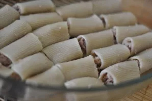 Fill the pasta with minced meat and put in a greased baking sheet.