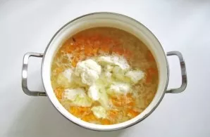 Rinse the rice and add it to the boiling soup. Divide the cauliflower into inflorescences and rinse. Put in a saucepan.