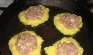 Pour vegetable oil into the pan and heat it. Pour the potato mixture with a spoon. Put a patty of minced meat on each pancake. Put anothe...