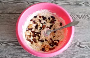While stirring, add the dried fruit and nut mixture. Add the remaining flour. Knead by hand.