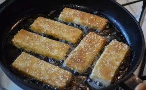 Heat the vegetable oil well over high heat, reduce the heat to medium and lay out the cheese slices. Fry quickly on all sides until golde...