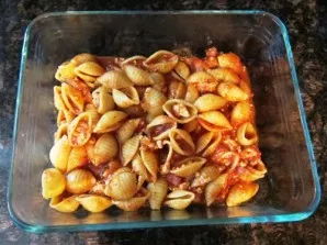 Add the pasta to the tomato sauce and mix well. Put half of the pasta in an oven-resistant container.