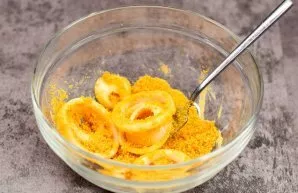The final step is to transfer the onion rings to a bowl with breadcrumbs. At the same time, put a small saucepan with vegetable oil on th...