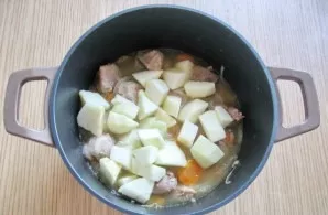 Peel one large or two small green apples, wash and cut into cubes. Put in a saucepan with pork.