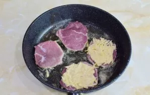 Pour vegetable oil into a hot frying pan and put the meat down the dough. Put more dough on top of the meat.