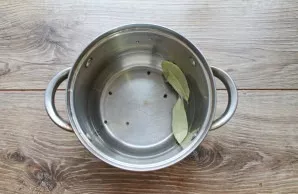 Pour water into a saucepan, add bay leaf and black pepper.