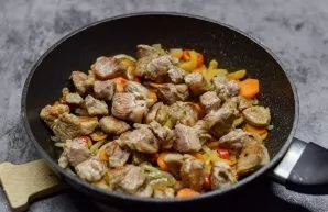 Cut the pork tenderloin into medium-sized pieces and fry over high heat until golden brown. Put the pieces of meat in a pan with vegetables.