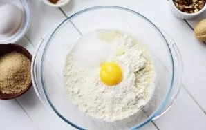 Pour all the flour crumbs from a blender into a large bowl, add white sugar, one egg yolk and cold water.