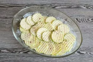 Take a heat-resistant form. Pour 50 grams of sour cream into it, add half of the chopped zucchini, add salt and spices to taste. Mix it u...