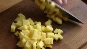 Peel the potatoes and cut them into cubes.