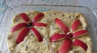 We give the dough a neat and beautiful shape. We wash the apple and cut it into thin slices, decorate the cake with them.