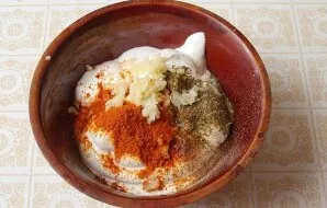 Prepare the salad dressing: add salt, black pepper, crushed garlic, suneli hops, paprika, turmeric, vegetable oil to the sour cream. Mix ...