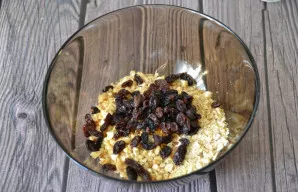 Add raisins to the mixture of oats and nuts.