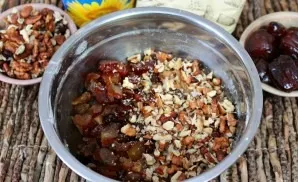 Cut the pitted dates into pieces, crush the nuts. Add dates and nuts to the dough and mix well.