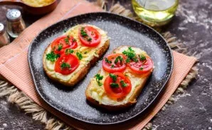 Put a little grated cheese and sliced tomatoes on top of the toast.