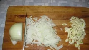 Meanwhile, finely chop the onion and garlic.