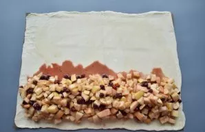 Pour the filling along the edge of the rolled dough.