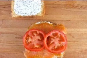 Then place salmon and tomato, cut into rings, on the second slice as well.