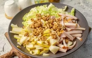 Dry the walnuts for a couple of minutes in a dry frying pan, then cut into pieces. In a salad bowl, add the nuts.