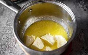 Put all the butter cut into pieces in a saucepan. Over low heat, stirring constantly with a spoon, melt the butter.