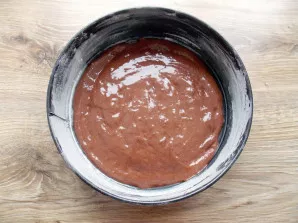 Grease the baking dish with vegetable oil and sprinkle with flour. Pour the dough into the mold and level it.