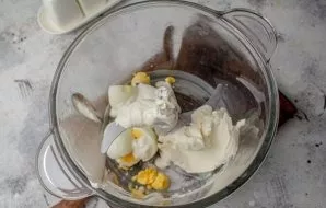 Put boiled eggs, cream cheese, sour cream in a chopper (blender) bowl.