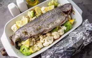 Transfer the fish to the vegetables. Cut the lemon into small slices, lay out on top of the vegetables and fish in the belly. Cover the t...