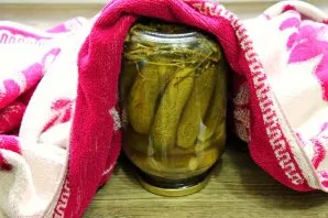 Drain the water from the jars and pour it with brine, close the boiled ones with lids and, turning over, wrap until cool.