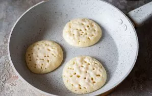 Heat a dry pan over medium-low heat. On a preheated pan, put one tablespoon of dough at a time when forming pancakes. Wait until holes ap...