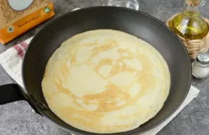 After some time, grease the heated pan with vegetable oil, pour in half a scoop of batter and fry the pancakes for 30 seconds on each sid...