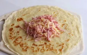 Place the sausage and cheese filling on the pancake.