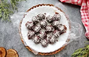 In a water bath, melt the chocolate and dip the candies in it. Put on a cling film and sprinkle with coconut chips on top. Leave until th...