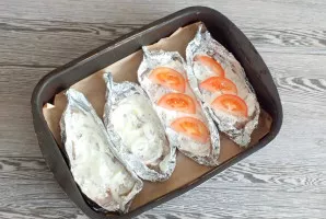 Salt each fillet, cover with sour cream, lay out the chopped onion. Place the tomato slices on top of the onion.