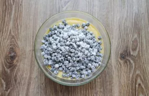 Mix the blueberries with one tablespoon of flour and add to the bowl of dough, mix.