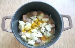 Salt the meat, add pepper. Add turmeric, cumin and dried basil.