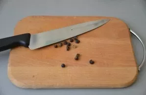 Crush the juniper berries with the flat side of the knife.
